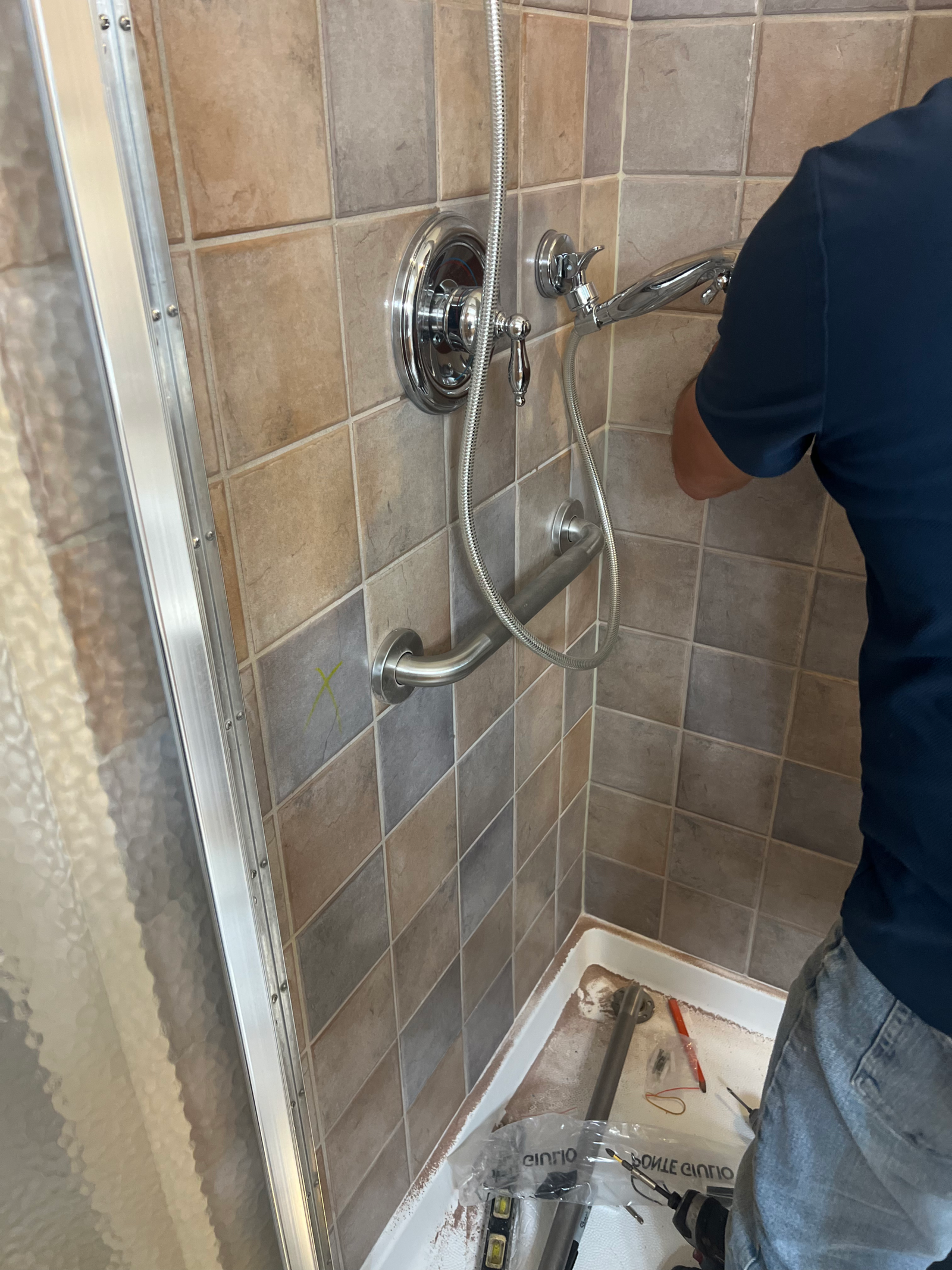 Grab bar installation in progress on a tiled Columbus shower wall